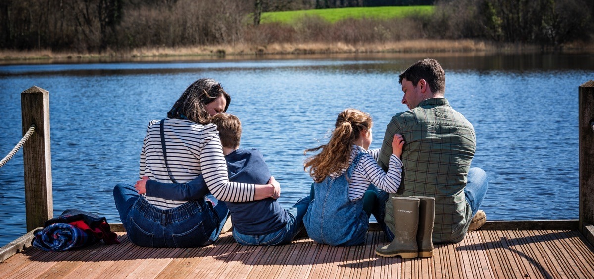 Family sitting on jetty at Blessingbourne Estate